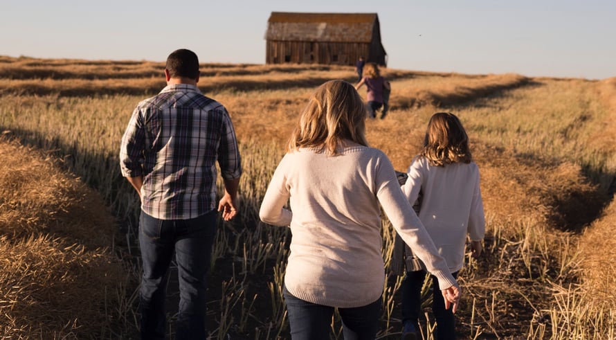 Family strolling through sunny meadow