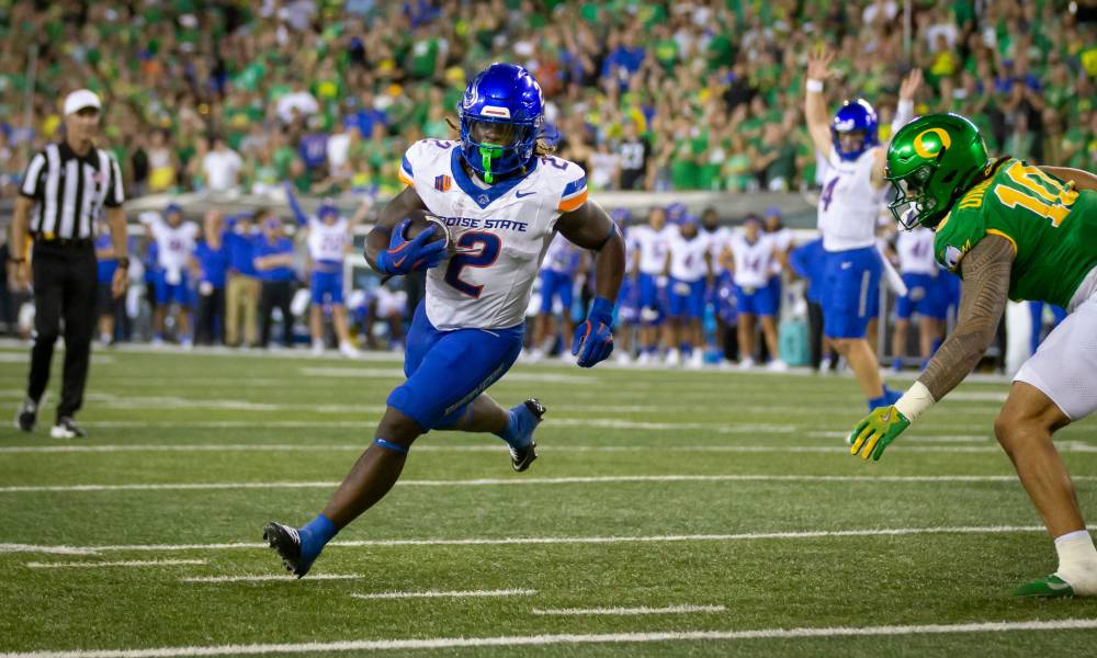 Football player sprinting with ball downfield