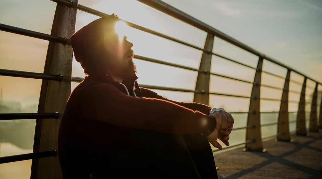 Man sits alone on bridge