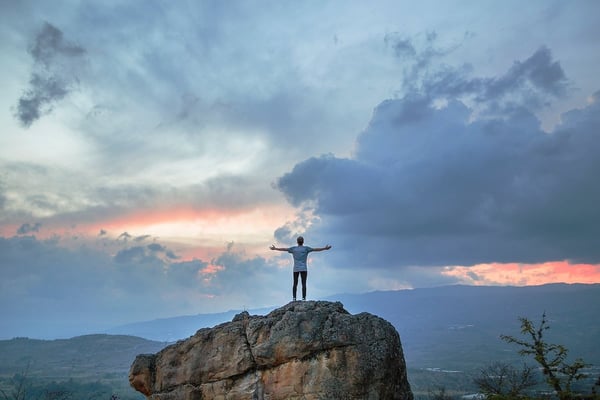 Man celebrating on mountain overlook