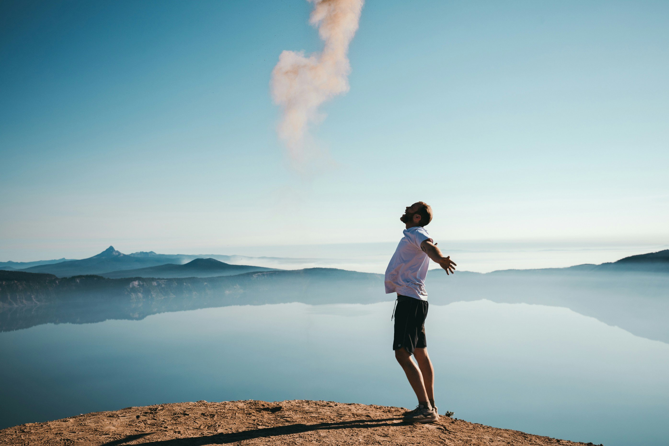 Man on cliff with outstretched arms